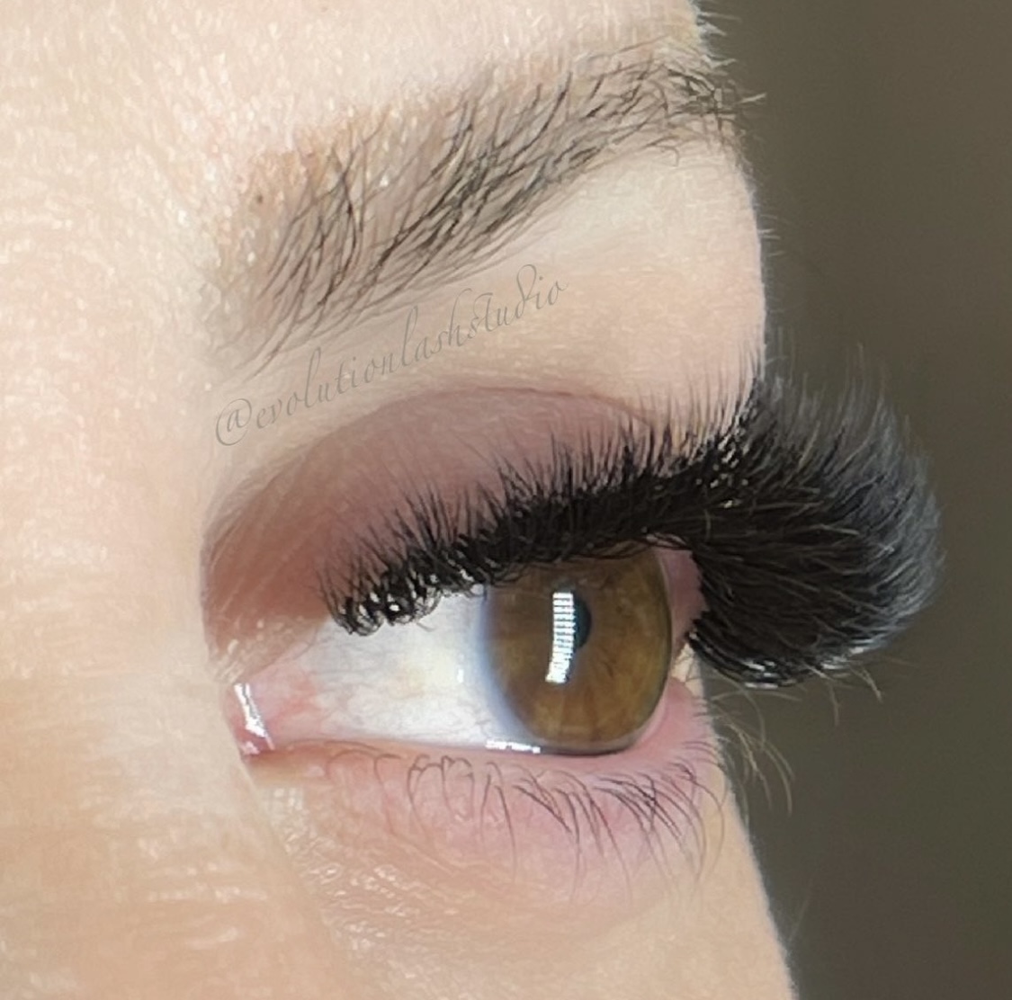 A full set of eyelash extensions on a woman with brown eyes
