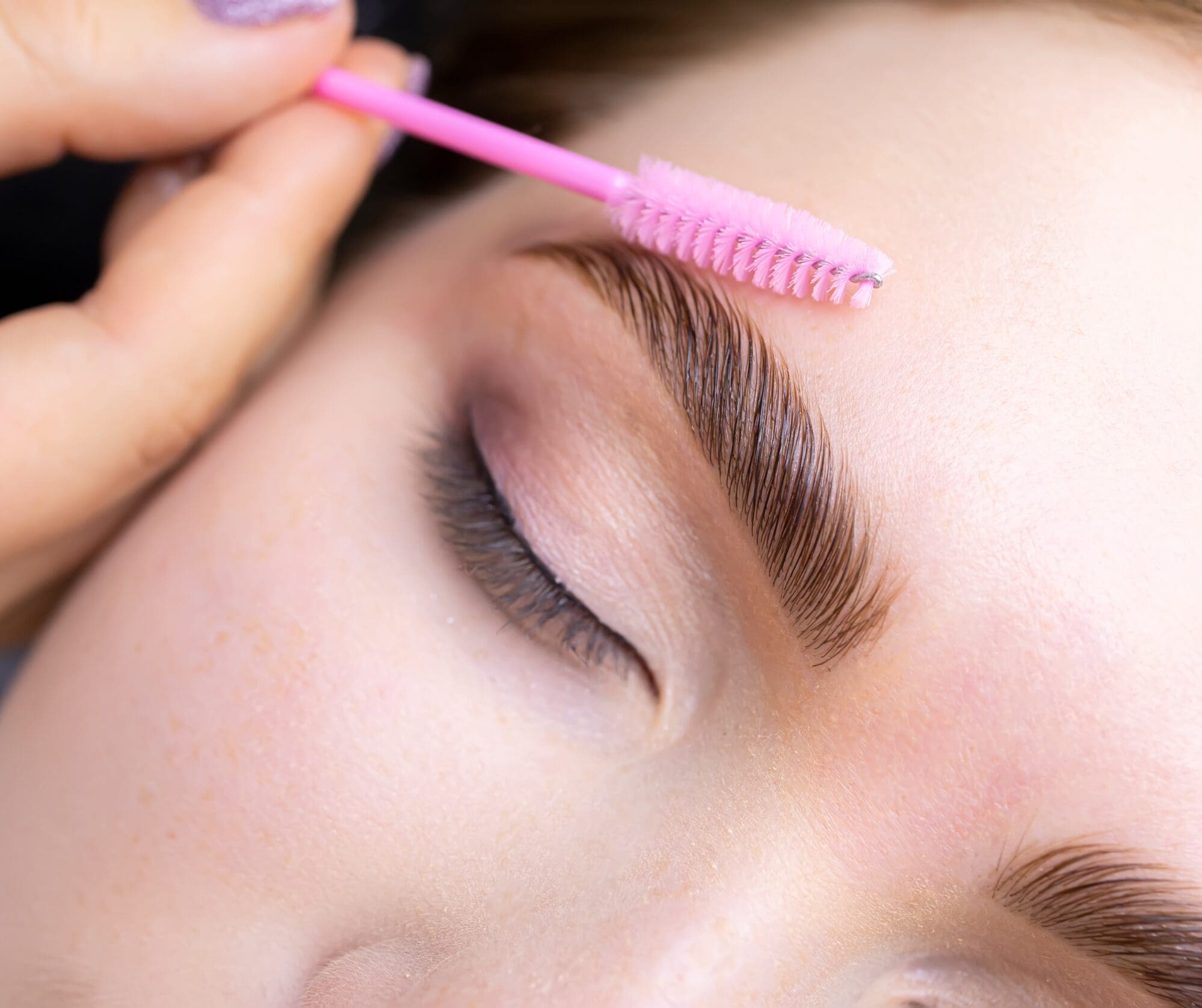 A woman receiving a brow lamination service