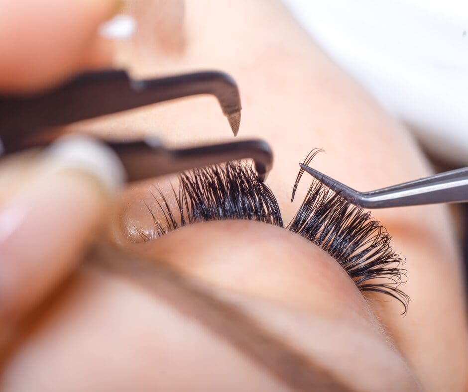 A technician applying false eyelashes to a woman
